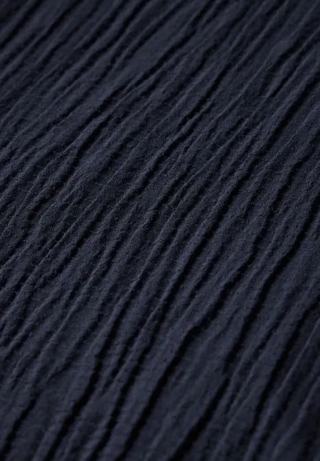 Dunkler, geknitterter Stoff mit wellenförmiger Textur.